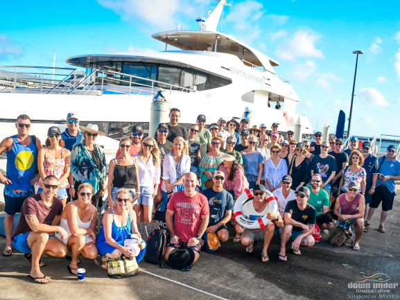 group photo of a private charter group Hot Tomato Public Relations down at Marlin Marina in front of Evolution ready for their full day private charter to the Outer Reef